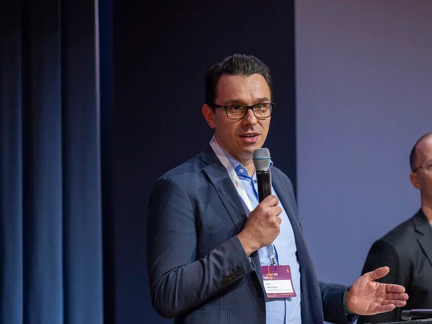 Dr. Artur Kokornaczyk speaking at a conference